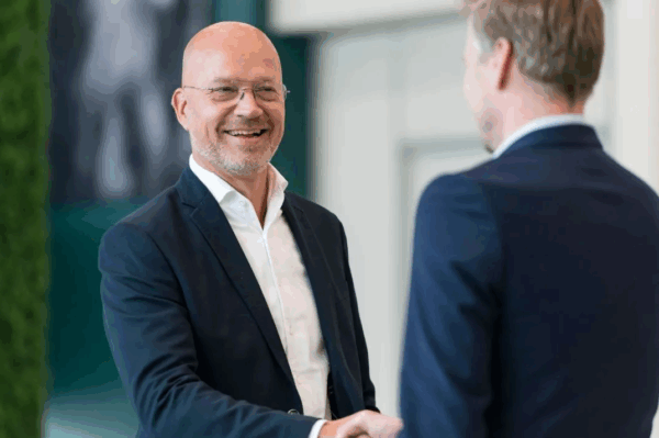 Foto van specialisten die elkaar de hand schudden. Risk Management